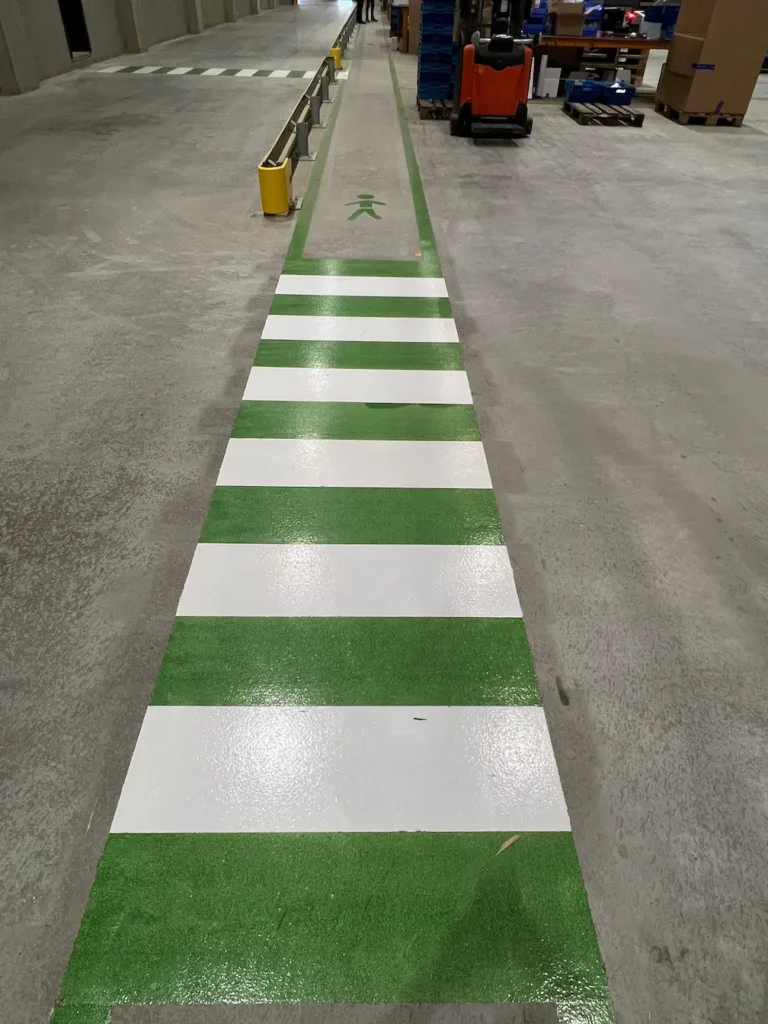 UV vloercoating met belijning in magazijn voor veilige looproute